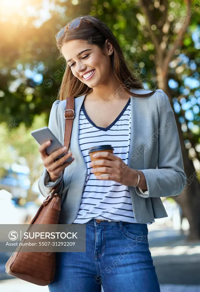 Im on the way. Cropped shot of an attractive young woman using her cellphone while commuting to work.