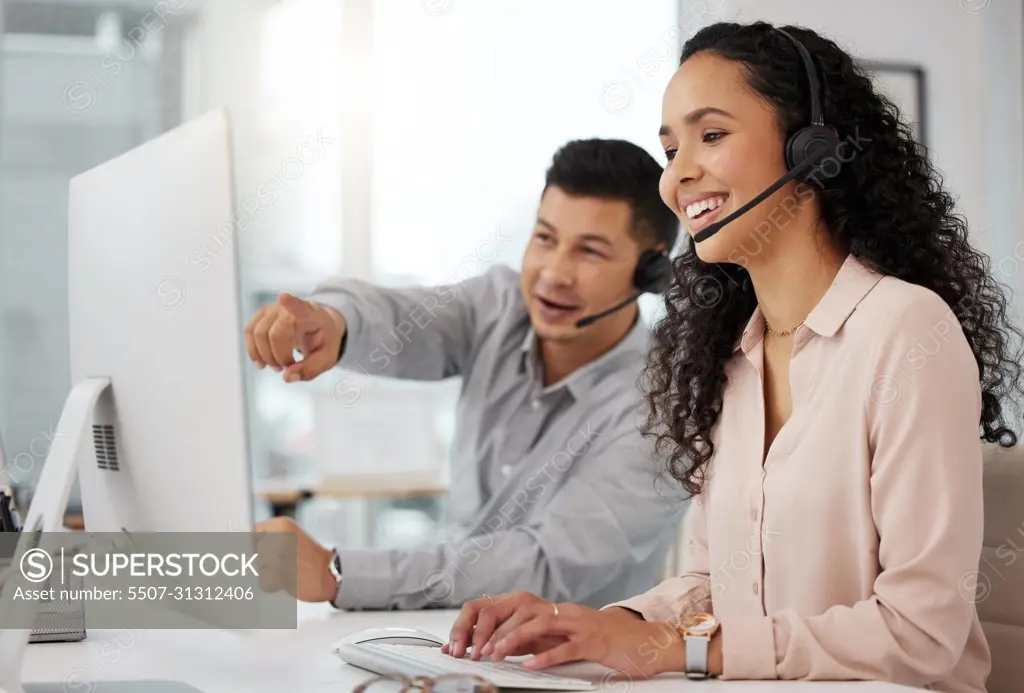 Sharing advice on how to better their services. Shot of two call centre agents working together on a computer in an office.