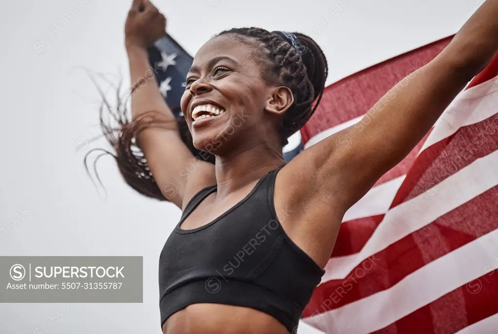 The training was worth it. Shot of a young female athlete holding a flag.