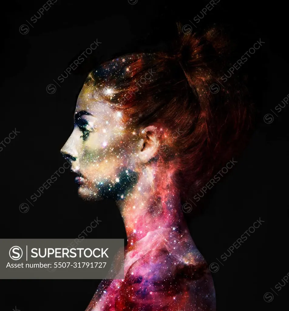 Intergalactic beauty. Profile of a young woman with the galaxy overlaid on her face.