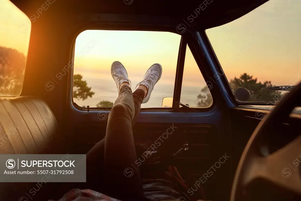 Roadtrip chill. Cropped shot of an unrecognizable woman lying in a car during a roadtrip.