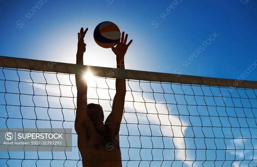 Denied. Shot of a beach volleyball game on a sunny day.