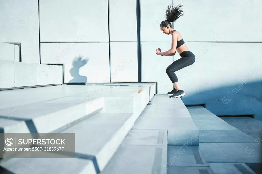 Taking it one step at a time. Full length shot of an attractive young female athlete exercising outside in the city.