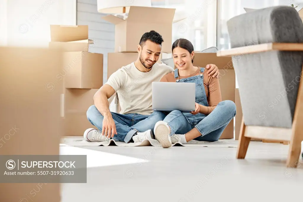 Lets see what furniture we can buy online. Shot of a young couple using a laptop while moving house.