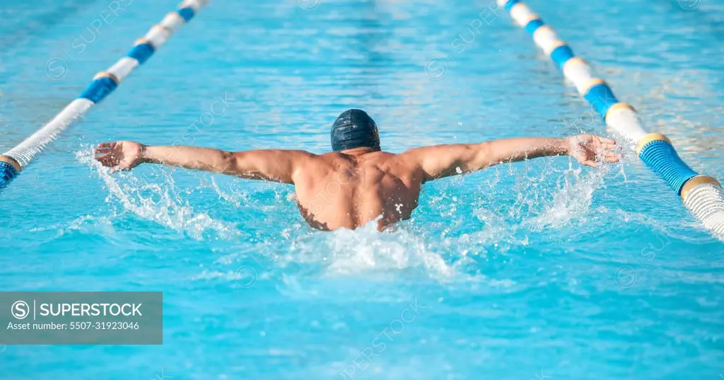 Thats some serious pace. an unrecognizable young male athlete swimming in an olympic-sized pool.