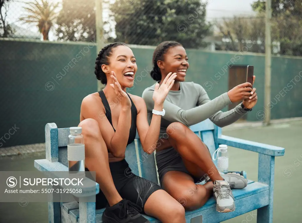 Cheering on their teammates. two attractive young female athletes sitting on a bench at a sports court watching a competition.