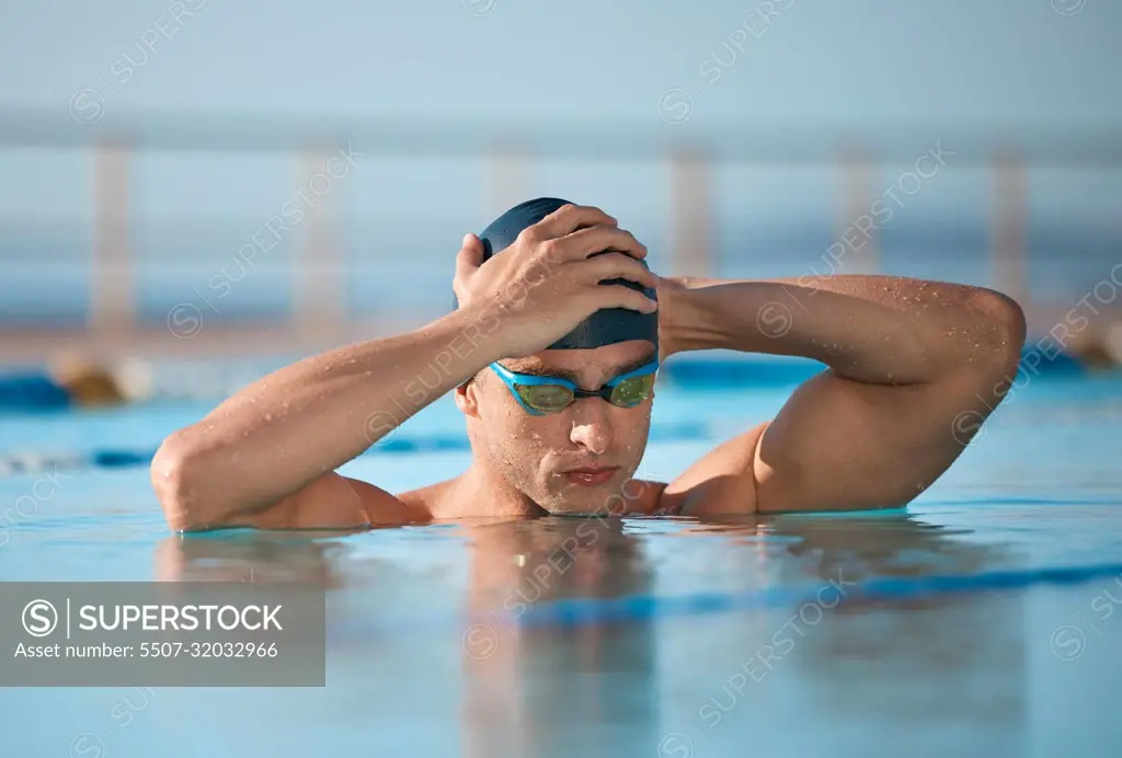 You cant put a cap on success. a handsome young male athlete swimming in an olympic-sized pool.