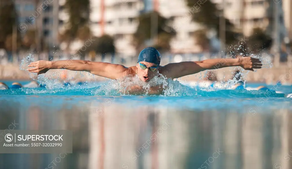 Aiming for a personal best. a handsome young male athlete swimming in an olympic-sized pool.