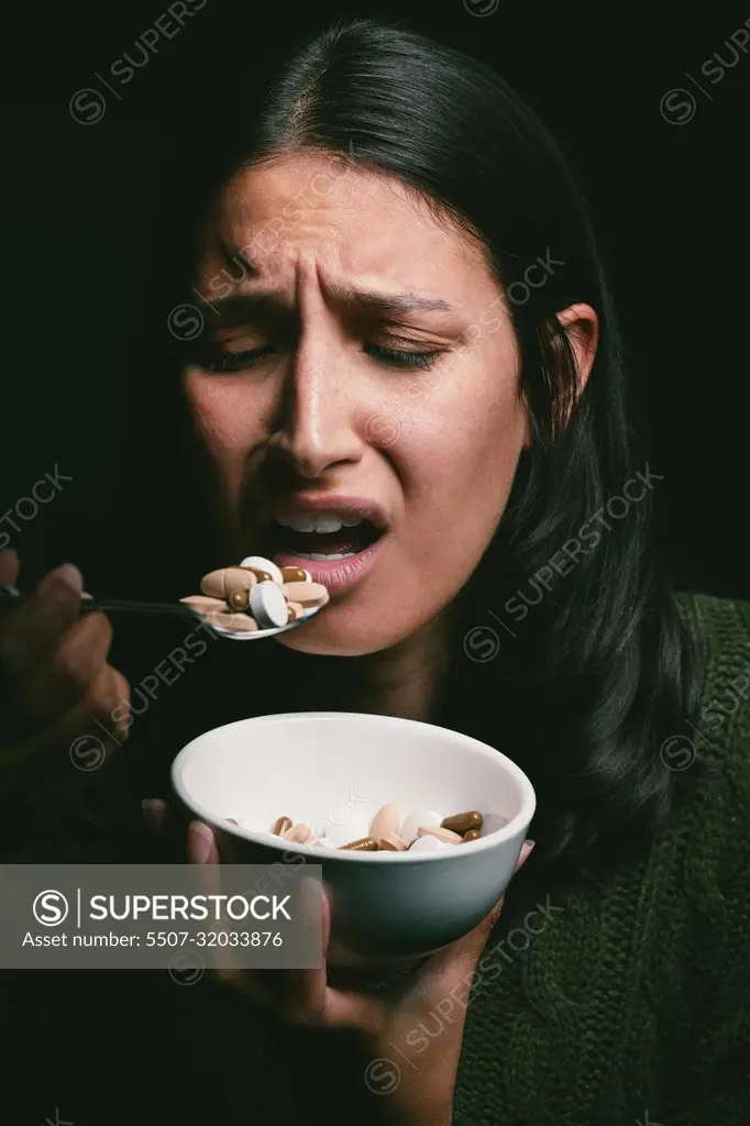 Check your diet. What is it doing to you. a young woman eating a bowl full of pills.