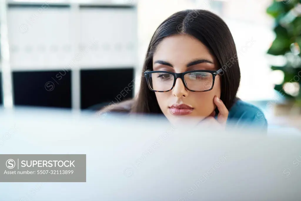 Work hard so you can achieve greatness. a young businesswoman working on a computer in an office.