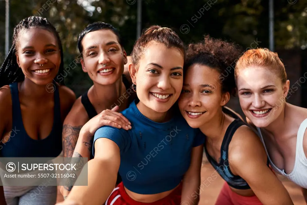 I couldnt have chosen better friends. a diverse group of sportswomen bonding after a basketball game together during the day.