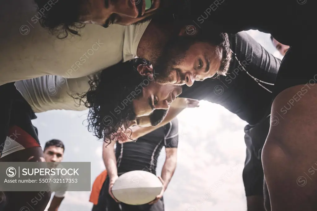 Here we go. Low angle shot of two young rugby teams competing in a scrum during a rugby match on a field.