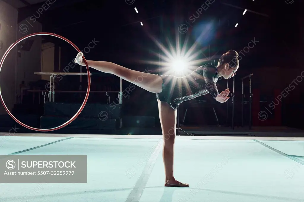 Gymnastics, dance and sport with a woman gymnast performance on a floor with a hoop or ring. Olympics, rhythm and agile dancer performing a routine, recital or training for a competitive event