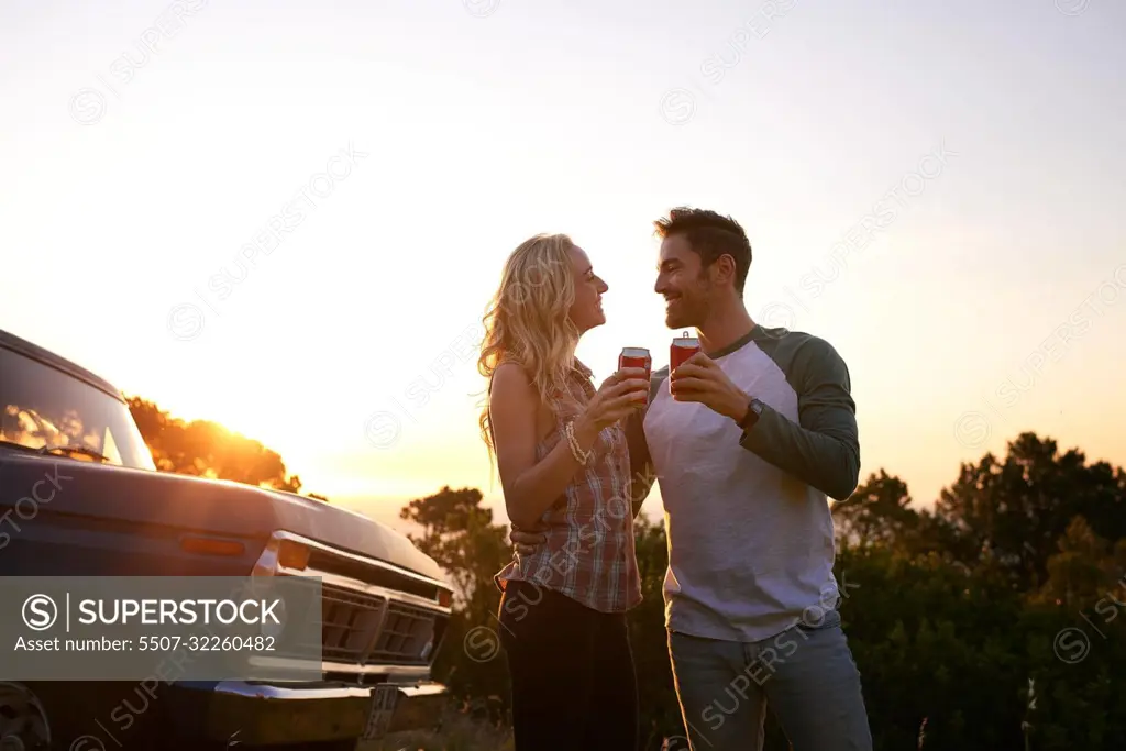 Heres to an amazing roadtrip. an affectionate young couple on a roadtrip.