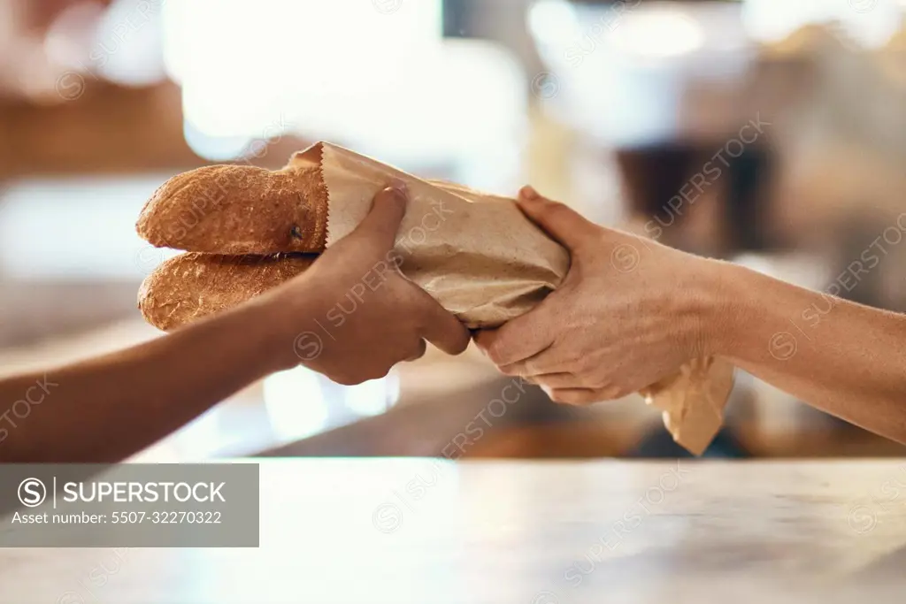 Customer buying bread from bakery, purchasing baked goods and shopping for food at a shop. Hands of female client and employee giving service, taking product and helping with item at grocery store