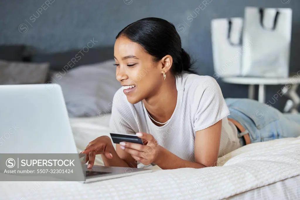 Credit card, online shopping and fintech woman with laptop, payment and financial internet or web banking. Economy, finance and buying and girl ordering products on website or app on home bed.