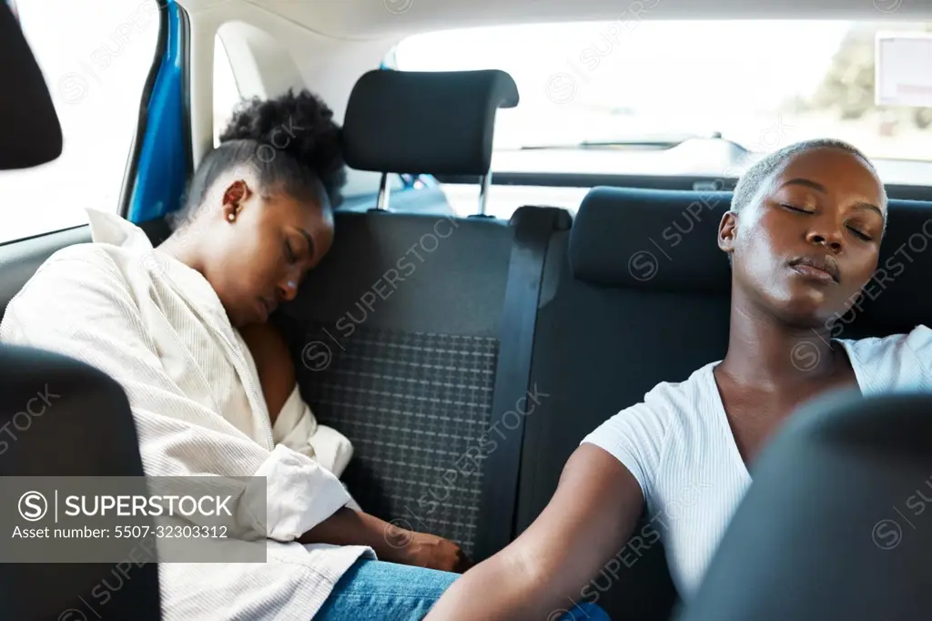 Lesbian couple sleeping in car or taxi after road trip, party and fun weekend as gay friends on vacation together. Tired African lgbt people, girls and women resting, relax and dreaming in back seat