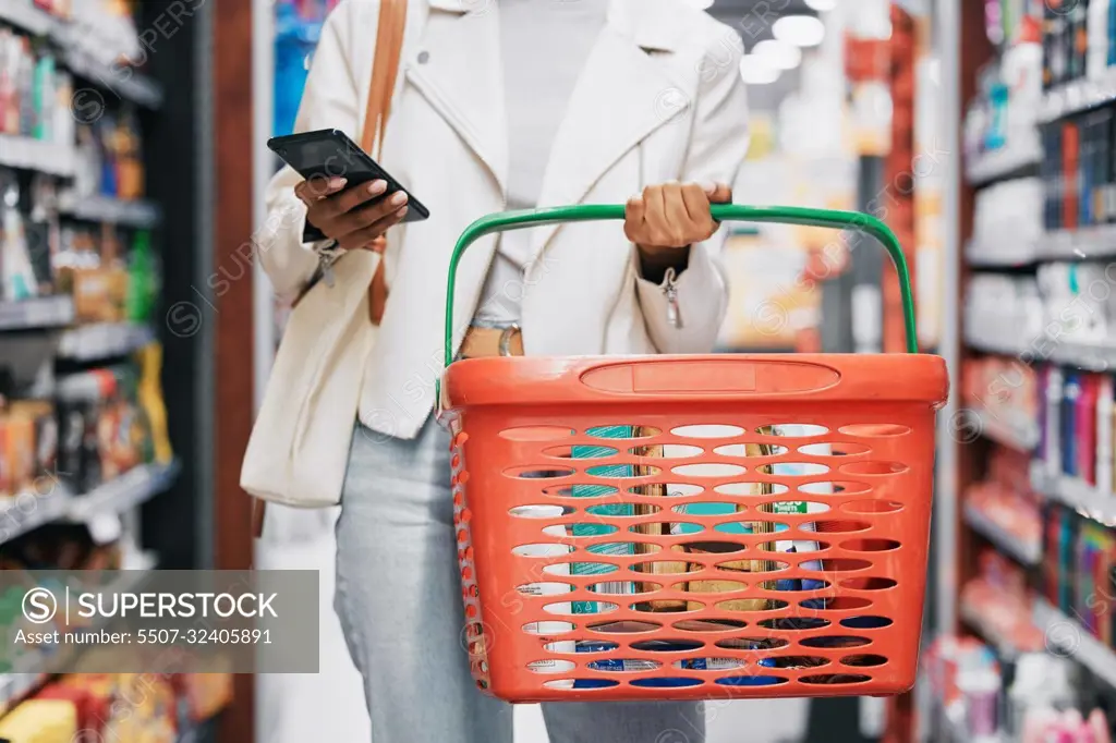 Grocery shopping, retail and black woman with phone in store, shop or supermarket. Girl buying groceries or purchasing products at a food mart or outlet while texting on mobile or smartphone.