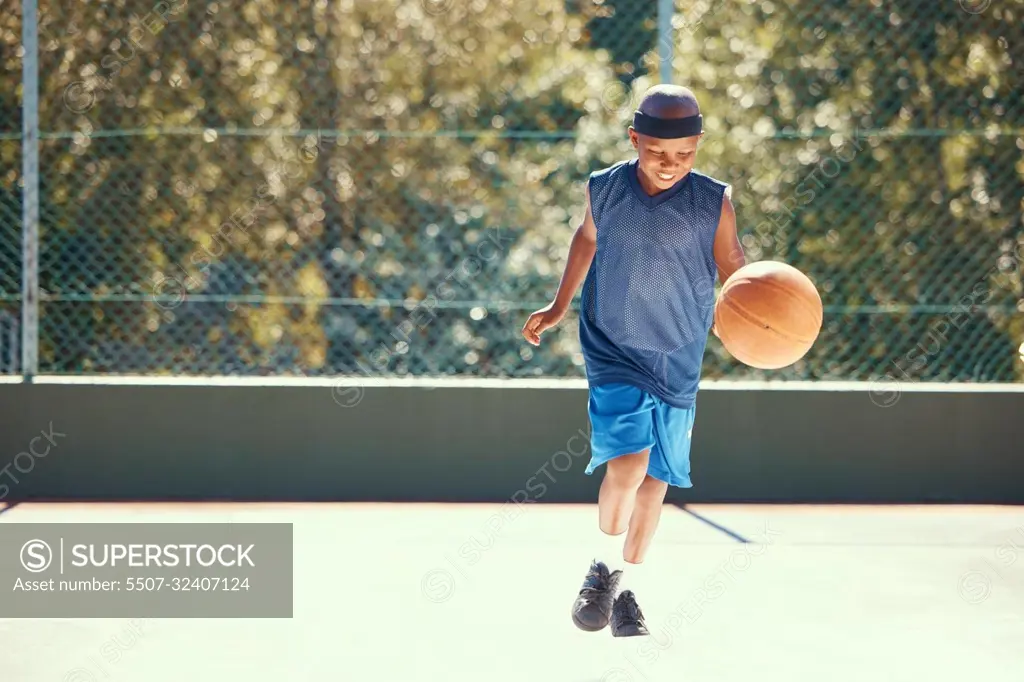 Sports, athlete and child basketball player training for a match on an outdoor court in nature. Exercise, workout and healthy boy practicing his skill for a game on a professional field.