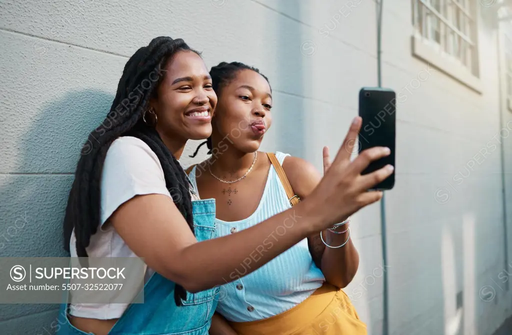 Black women, friends and phone selfie in city, street or outdoor. Relax, bonding and African girls spending quality time together, comic face and sharing picture post on social media with 5g mobile.