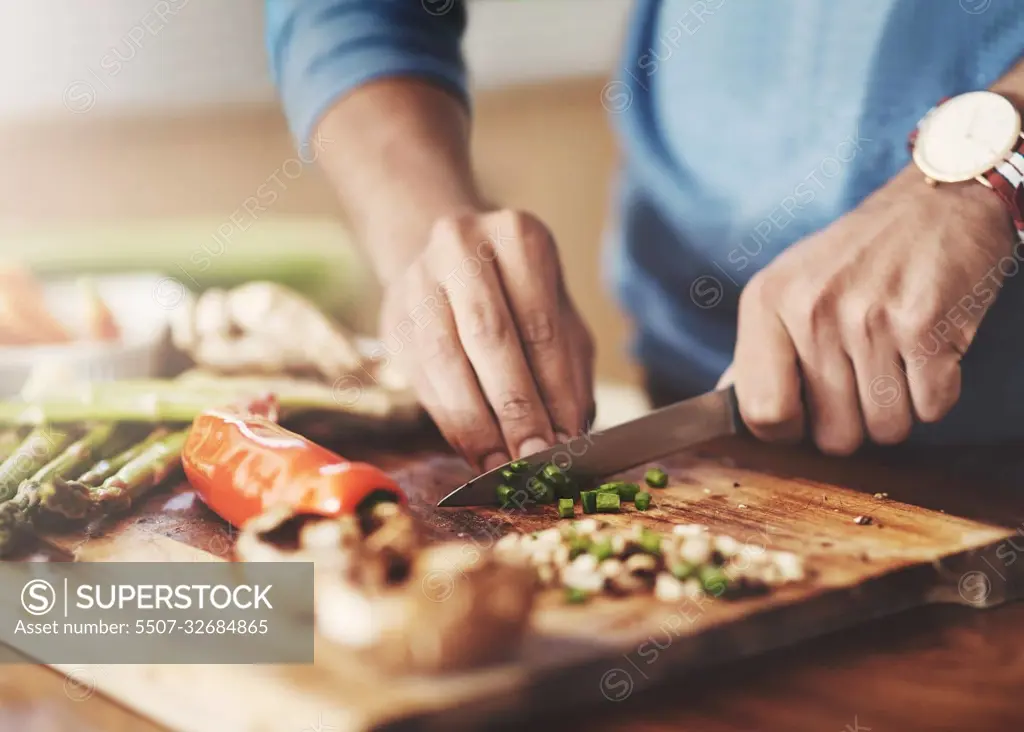 Taking a slice out of the healthy life. a man preparing a healthy meal at home.