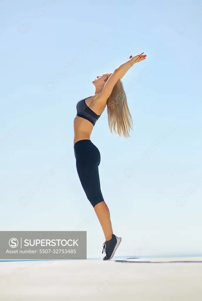 A Young Woman With Arms Stretched Out To The Sky Stock Photo