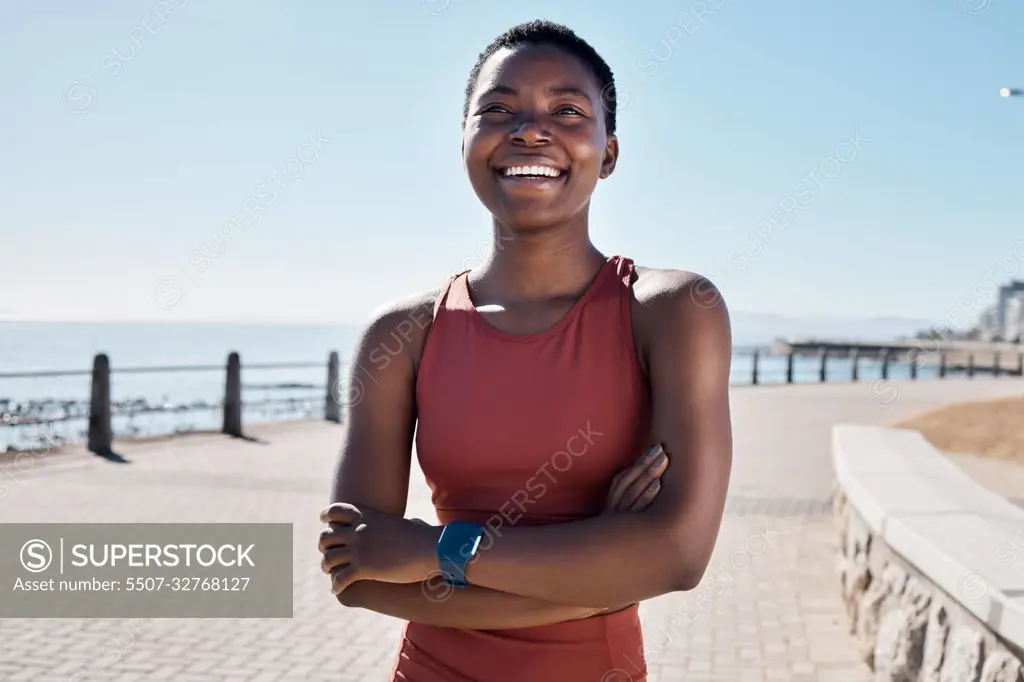 Fitness, happy black woman and thinking on beach sidewalk of vision, mindset and motivation for summer body goals, healthy exercise and wellness. Female sports athlete, smile and arms crossed at sea