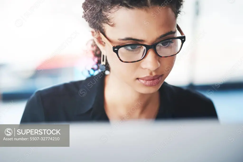 Great things happen when hard work and dedication merge together. a young businesswoman working on a computer in an office.