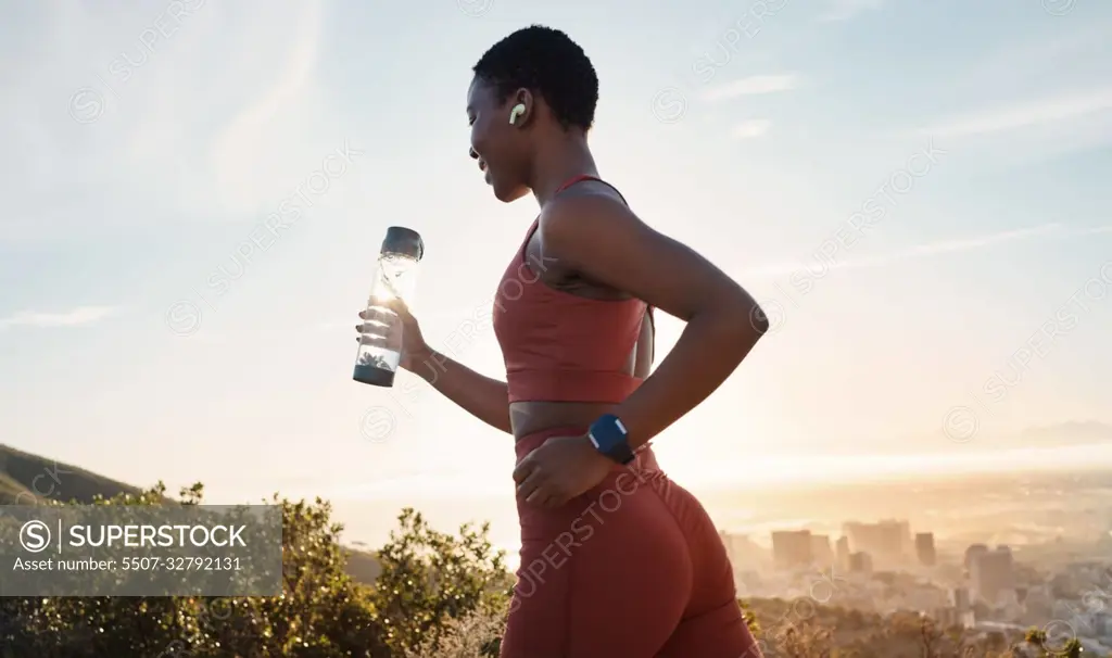 Workout, black woman or sunset with runner training, exercise for wellness, health or hydration. African American female, lady or athlete with water bottle, practice for marathon or fitness in nature