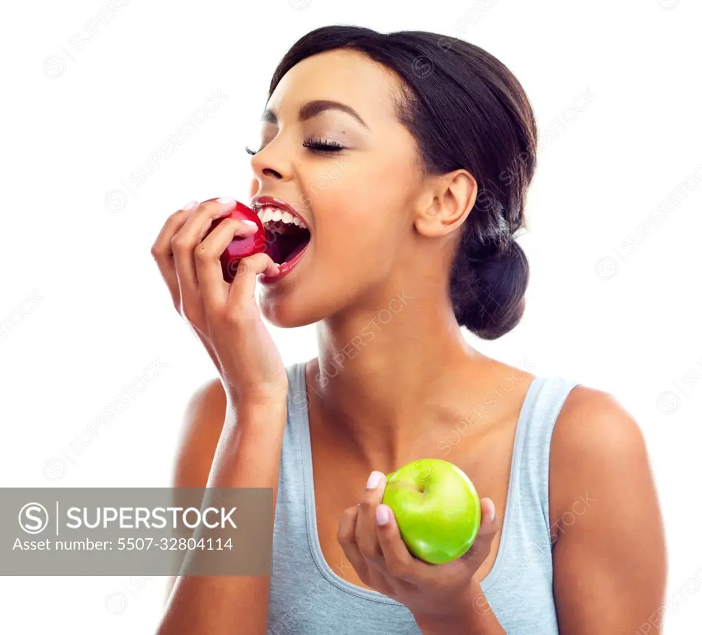 Tasty and healthy. Studio shot of a young woman in gymwear biting into an apple.