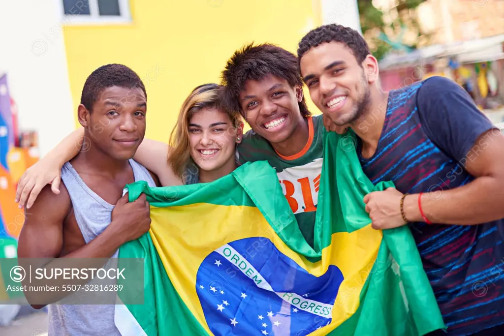 Proud of their nation. Portrait of a group of teenagers holding up the Brazilian flag.