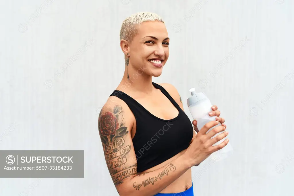 I stay hydrated. Cropped portrait of an attractive young female athlete drinking water against a grey background.