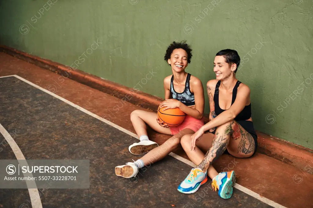 We always laugh when were together. a diverse group of sportswomen bonding after a basketball game together during the day.