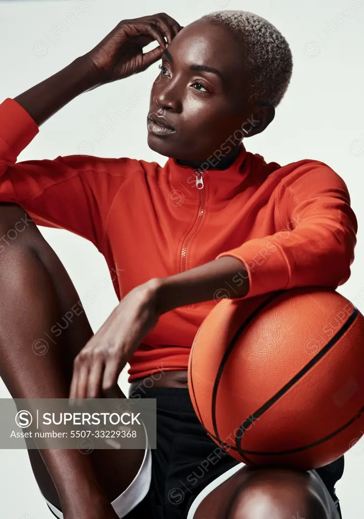 Whats life without basketball. Studio shot of an attractive young woman playing basketball against a grey background.