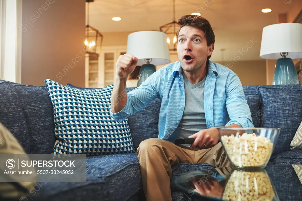 Real sports fans watch the game in real time. a young man watching an exciting sports match on tv.