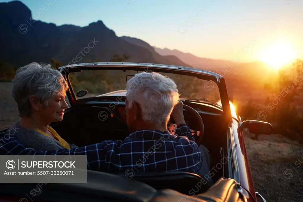 In love with each other, In love with life. an affectionate senior couple enjoying the sunset during a roadtrip.