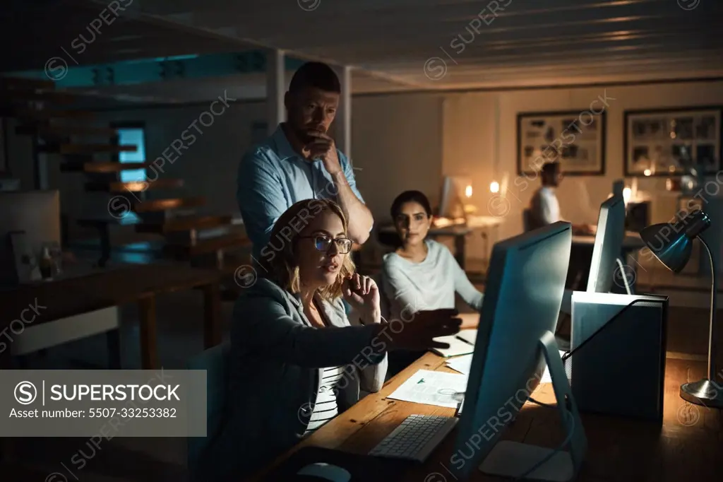 Getting it done quicker with everyones input. a group of businesspeople working late in an office.