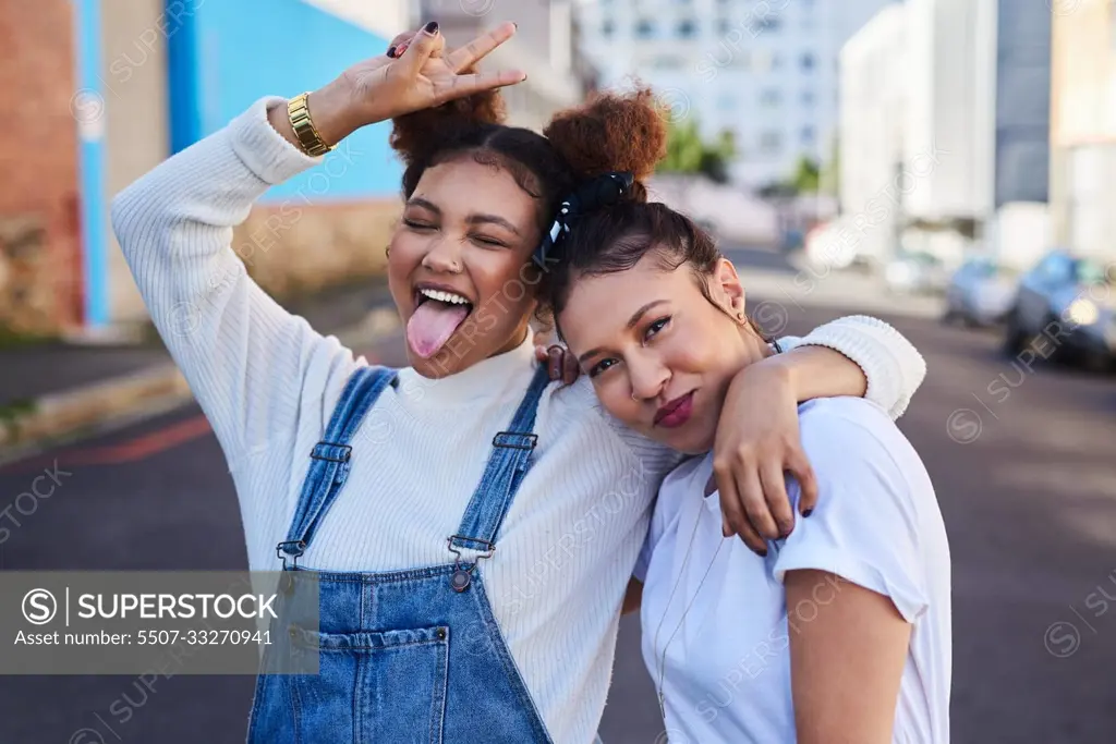 Were off to that white and denim party. two young woman out in the city during the day.