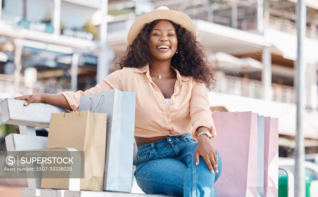 Black woman, retail shopping bag and outdoor bench break from travel buying, sales and summer market retail fashion promotions in San Francisco California. Happy portrait of wealthy customer spending