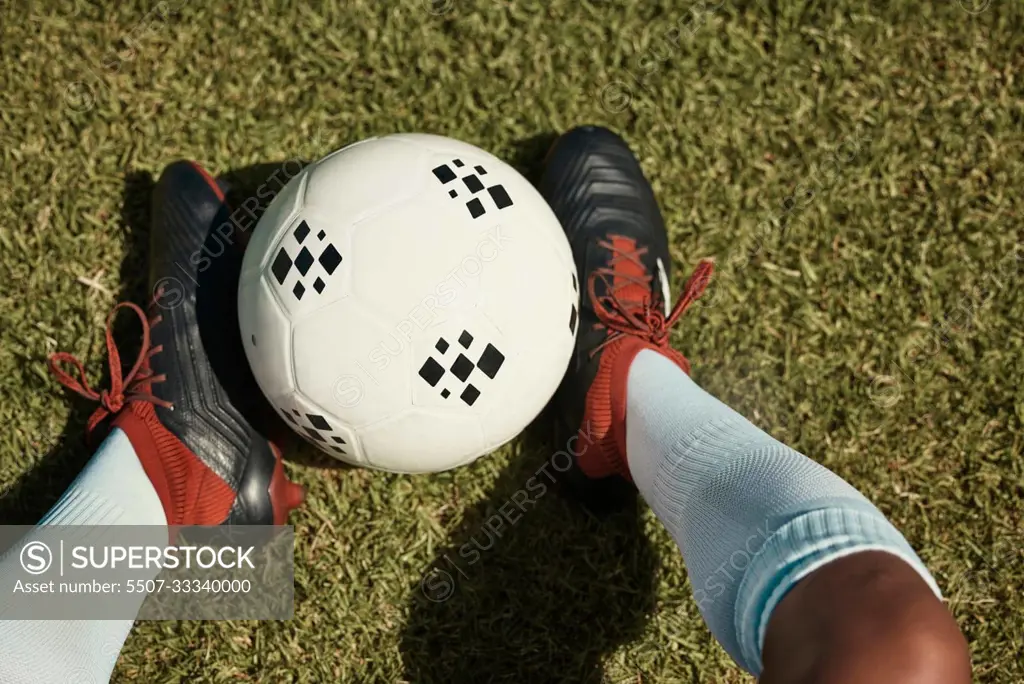 Soccer ball, grass field and shoes, soccer player and sport, athlete feet and fitness, sports game and training closeup. Soccer, ball and exercise, soccer field and outdoor, green and competitive.