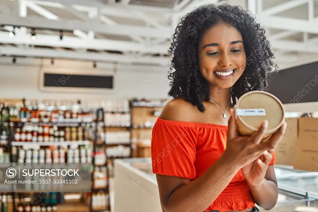 Supermarket, black woman and shopping, groceries and happy with product in retail shop, customer check ingredients. Grocery store, sale on food and drink, happiness with shop choice and buying.