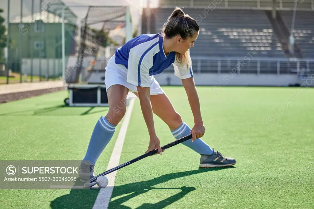 Sports, hockey and woman in action on field with hockey stick ready to hit ball in game. Fitness, exercise and female athlete playing field hockey in outdoor stadium for workout, training and health