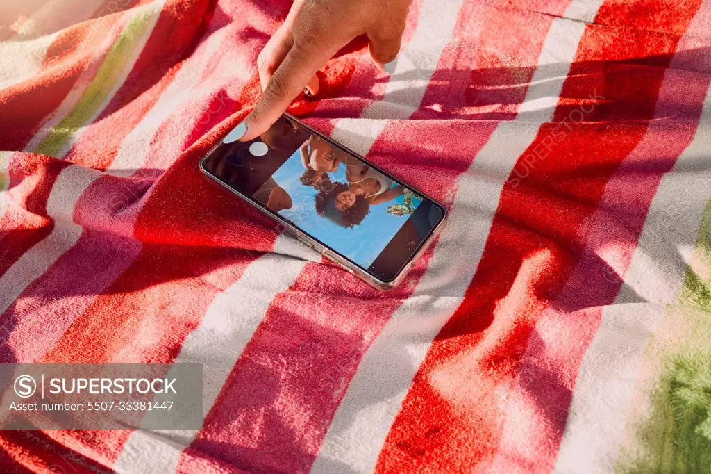 Hand, phone and selfie by friends at a beach for travel, fun and picture on towel, finger and screen. Women, hands and social media influencer set timer for recording, content creator and smartphone