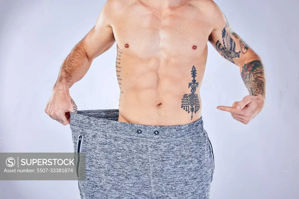 Lose weight, fitness and man stomach, body and muscle results check for diet, workout or exercise wellness goals in studio. Athlete, sports model hand show training success or weight loss progress