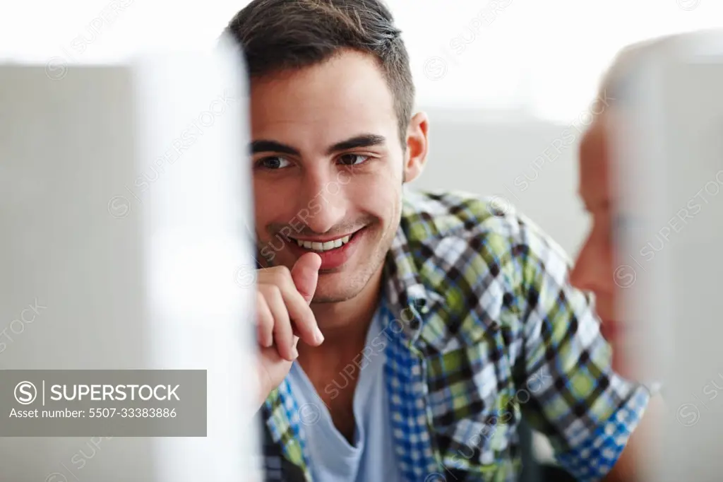 Hes happy with her work. Two colleagues working on a computer together.