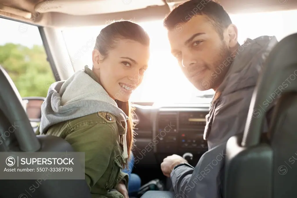 Theres nothing but sunshine and happiness on our roadtrip. Portrait of a young couple on a roadtrip.