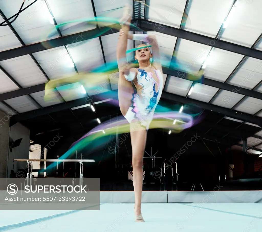 Creative, ribbon and motion blur with a woman gymnast in a studio for olympics dance training or exercise. Fitness, art and gymnastics with a female dancer in a gymnasium for rhythmic practice