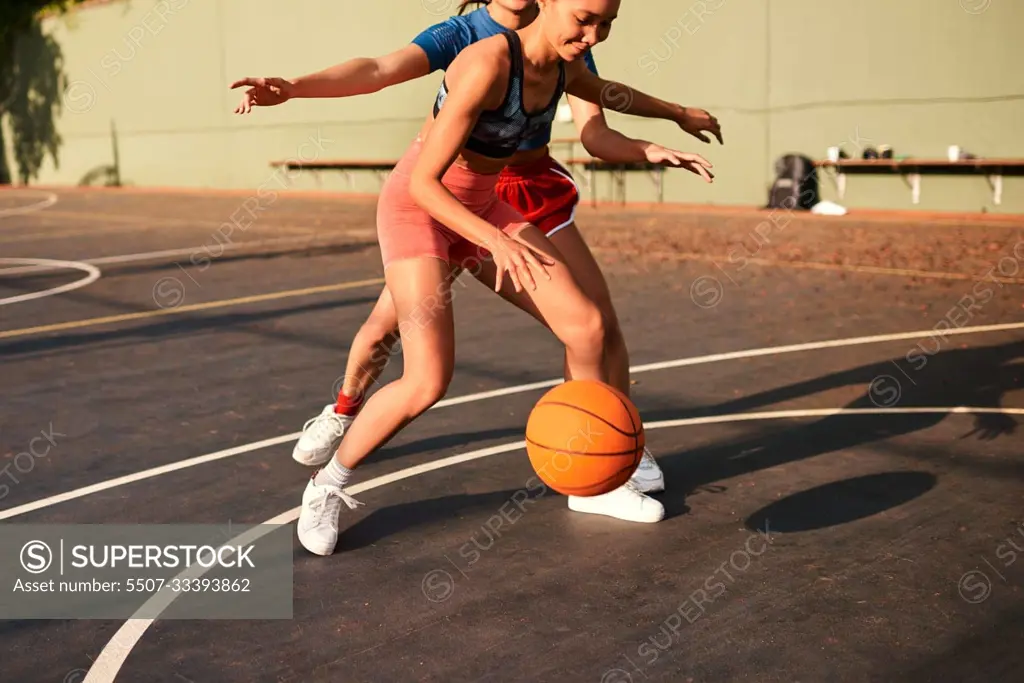 Shes putting me under pressure. an attractive young sportswoman blocking her opponent during a basketball game during the day.