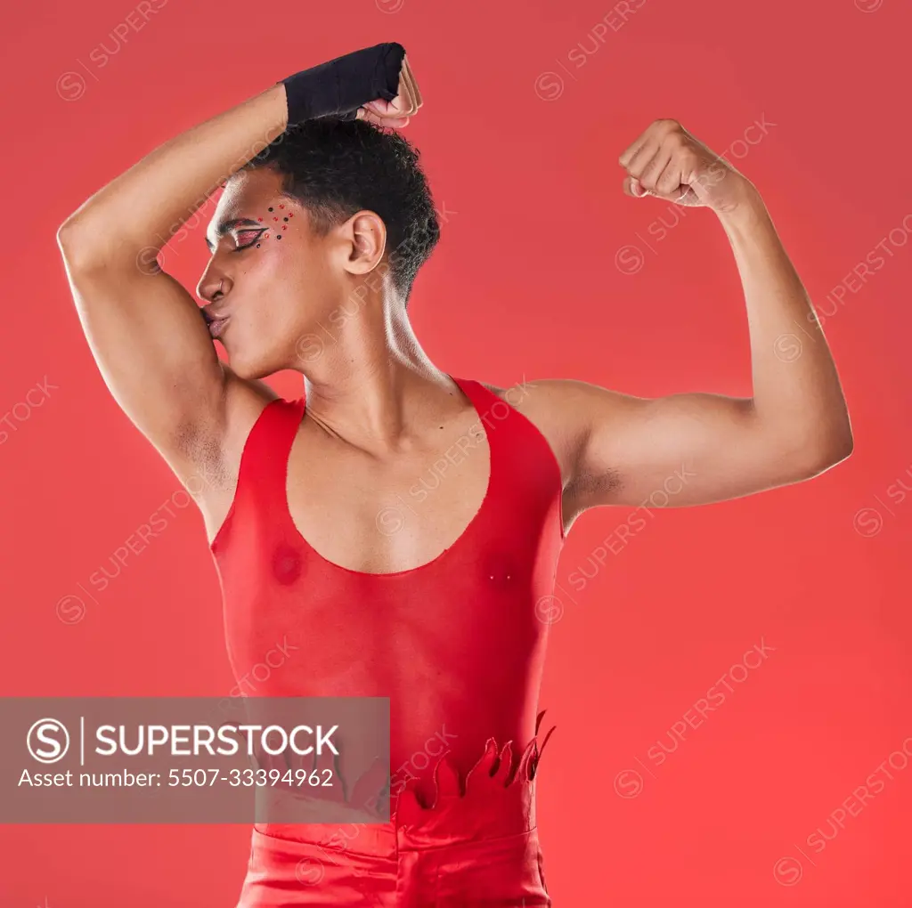 Man, studio and arm muscle kiss with wrestling, punk costume and makeup for  lgbt aesthetic by red background. Young bodybuilder, gen z gay and fitness  with strong body, self care and pride