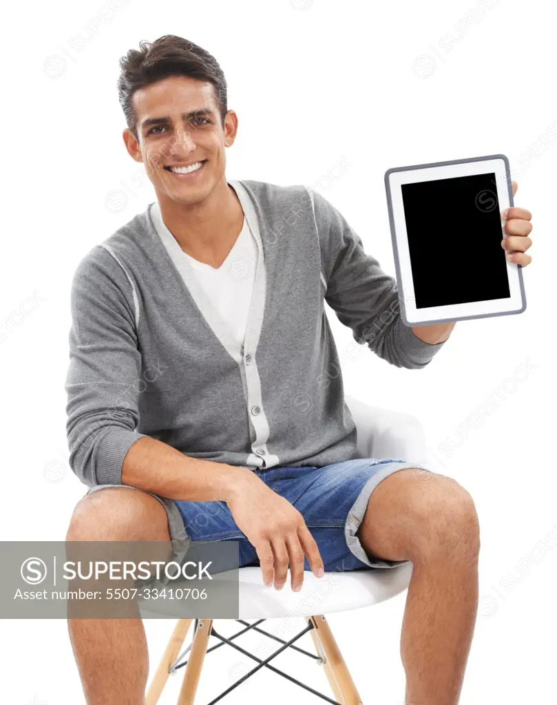 The next big meme. Studio shot of a young man sitting in a chair showing a  blank tablet screen to the camera. - SuperStock